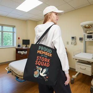 Woman carrying a black tote bag with the phrase “Proud Member of the Stork Squad” in a hospital room, perfect gift for labor and delivery nurses or NICU teams.