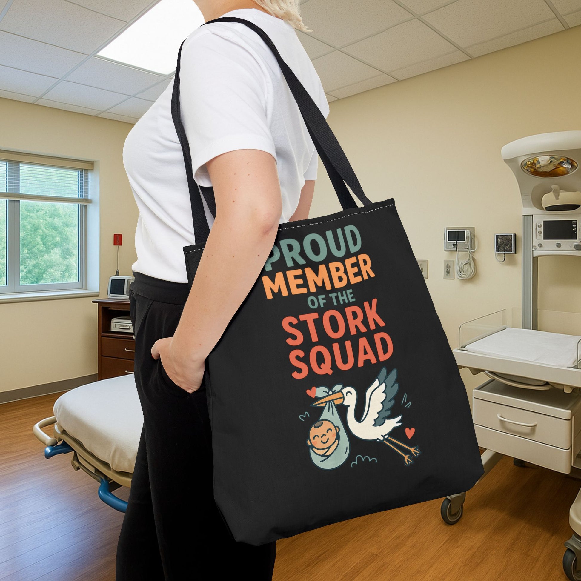 Funny nurse tote bag with bold lettering and cute stork art, carried by a woman in scrubs — a great accessory for expecting moms or hospital staff.

